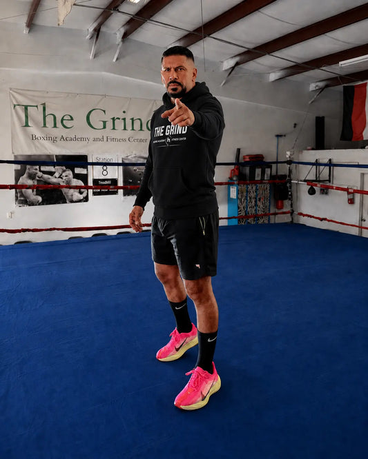 Coach Manny wearing The Grind hoodie inside The Grind Boxing Academy ring