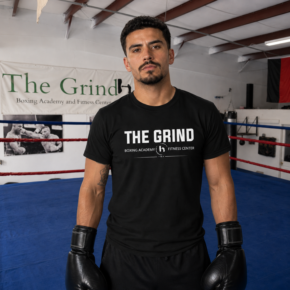 Model wearing The Grind Boxing Academy logo T-shirt inside The Grind gym