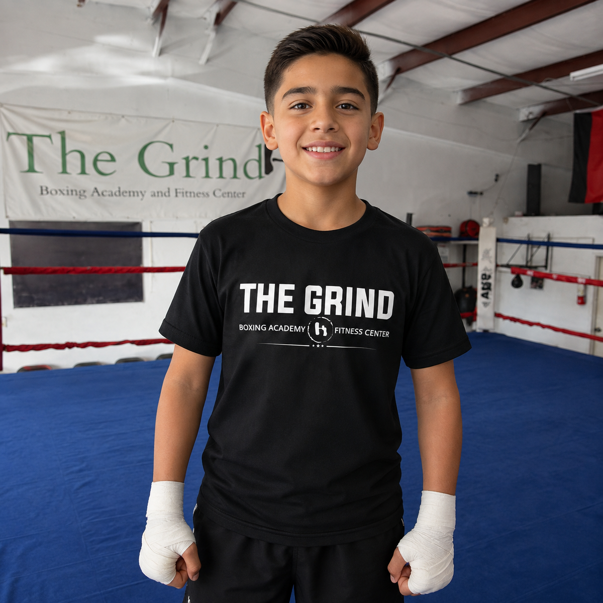 Youth boxer wearing The Grind Youth Training Tee inside The Grind gym